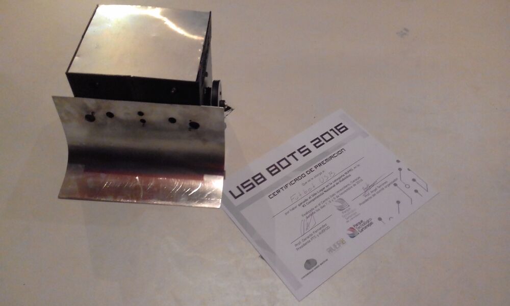 The bare-metal Atlas chassis with its scoop blade next to the USB BOTS 2016 certificate for 2nd place in the Sumo category