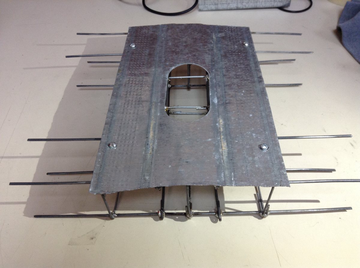 The robot's welded steel-wire chassis frame, with a sheet-metal deck riveted on top and a cutout for the camera